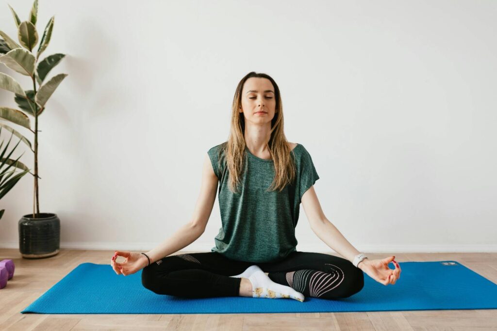 A calm individual meditating on a yoga mat