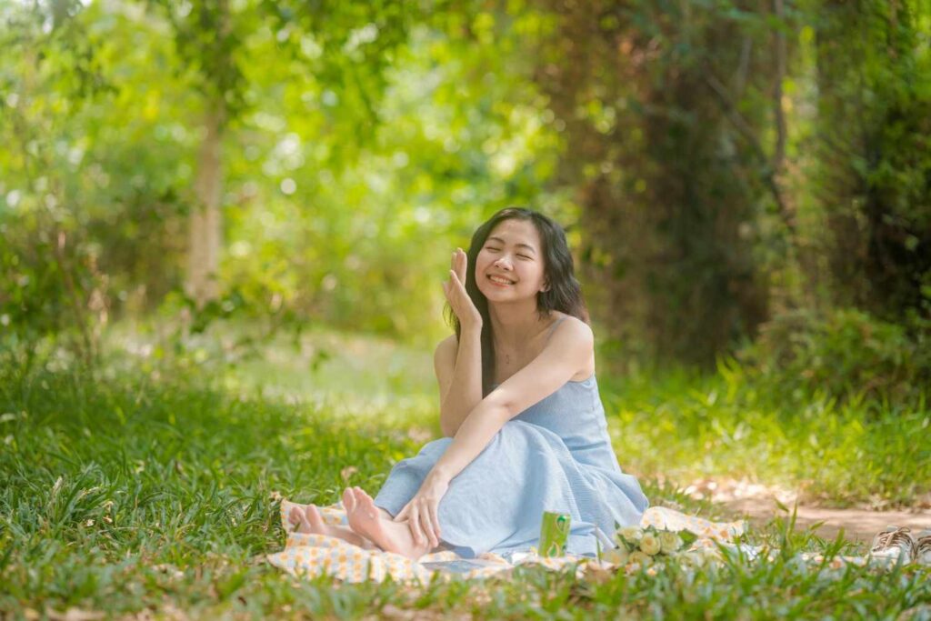 An individual enjoying sunlight in a park.