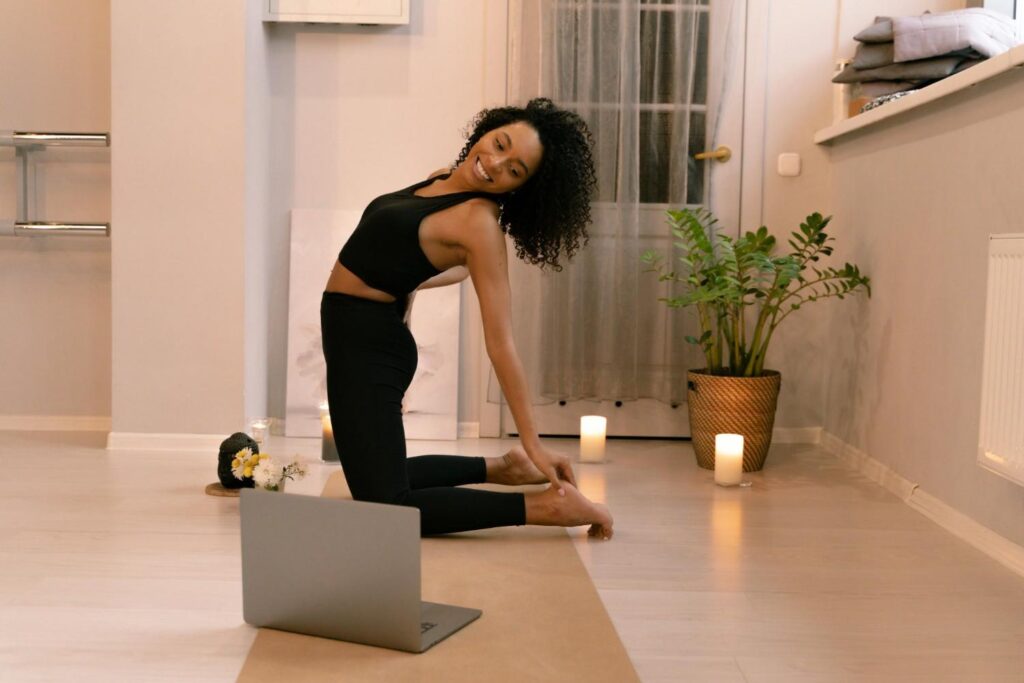 woman practicing online yoga at home looking at her laptop